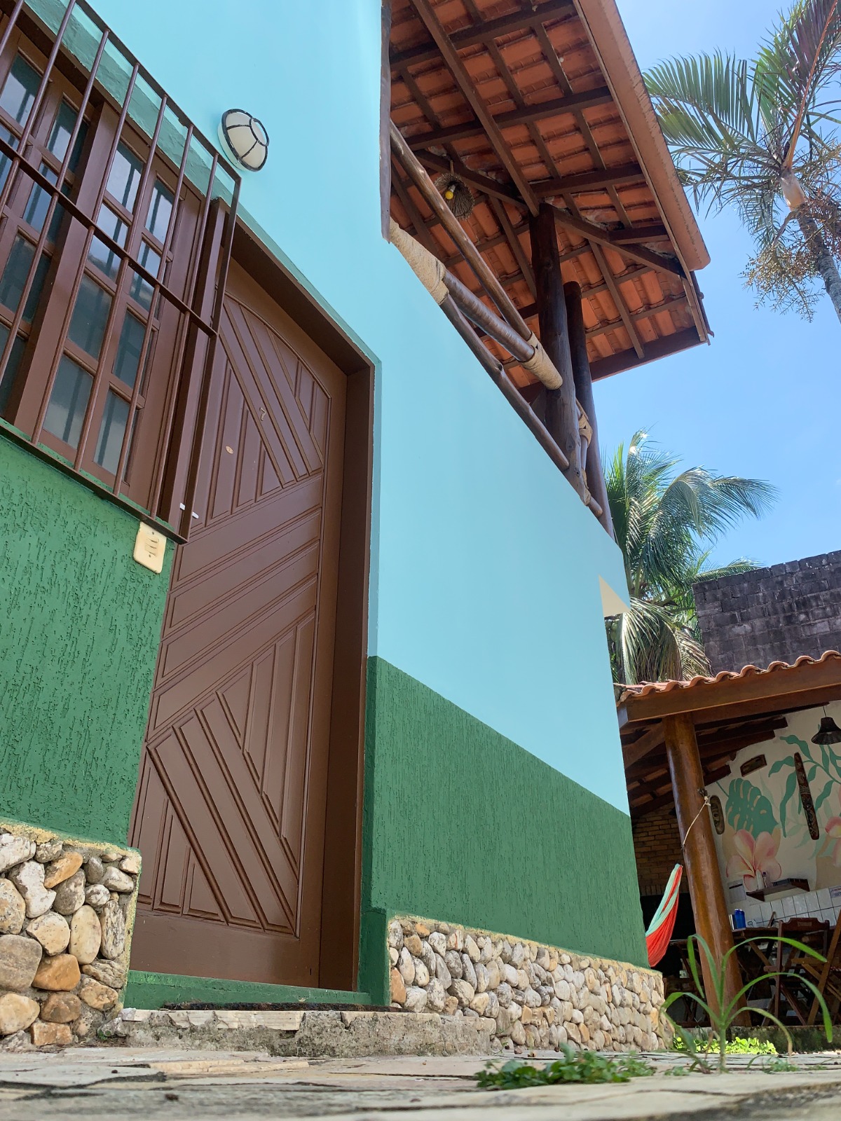 Fachada do chalé com palmeira